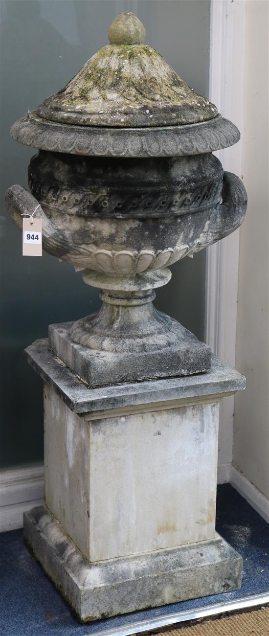 A weathered composition garden urn and cover, on squared pedestal, H.3ft 9in.